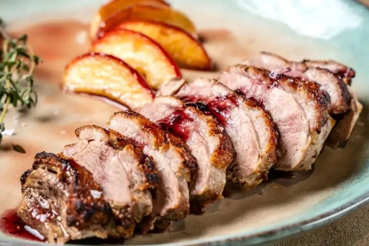 Soczysty filet z kaczki z jabłkami, polany aromatycznym sosem. Idealne połączenie smaków na talerzu.